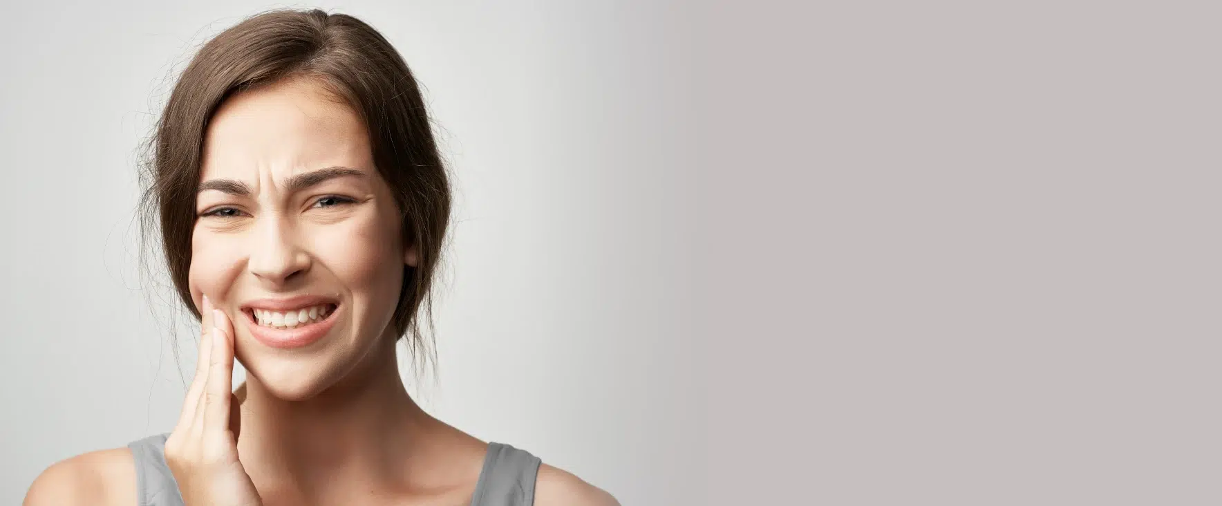 Woman with severe tooth pain needing an emergency dentist in Taylor, TX